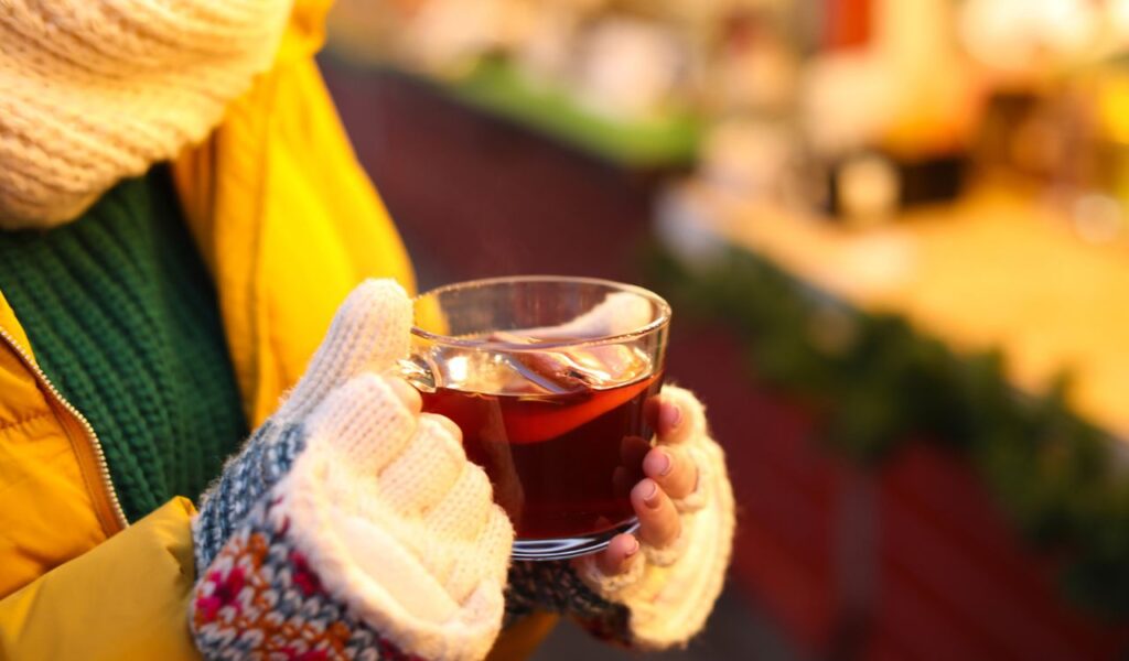 Woman with mulled wine at winter fair, closeup
