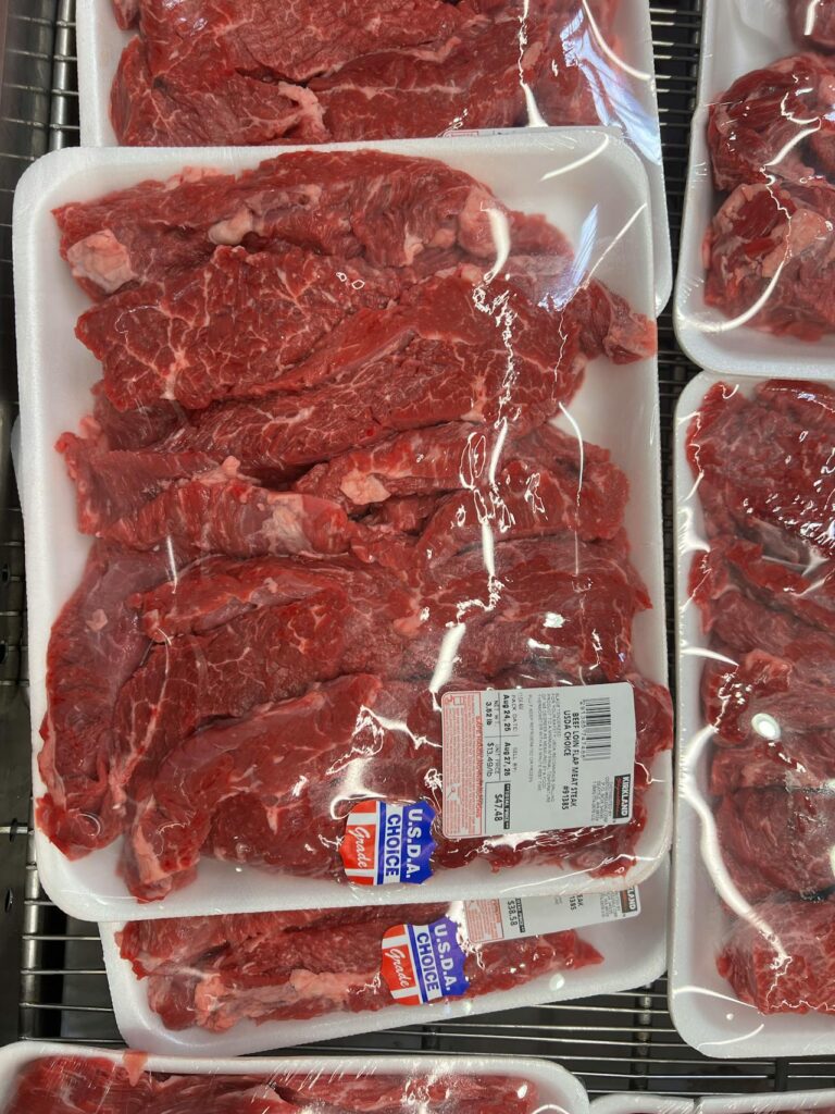 A package of raw chicken or beef sitting on a kitchen counter at room temperature.