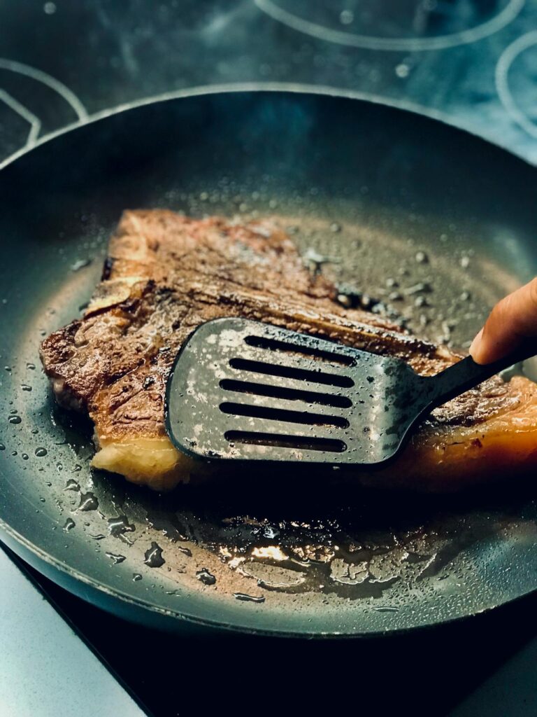 Steak in a cast-iron skillet with a browned crust.