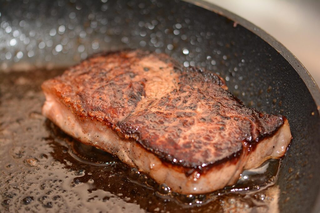 Pan-searing close-up with butter and herbs.