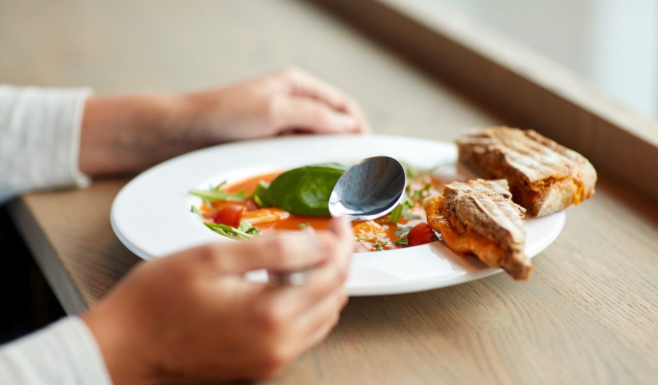 woman eating gazpacho soup at restaurant