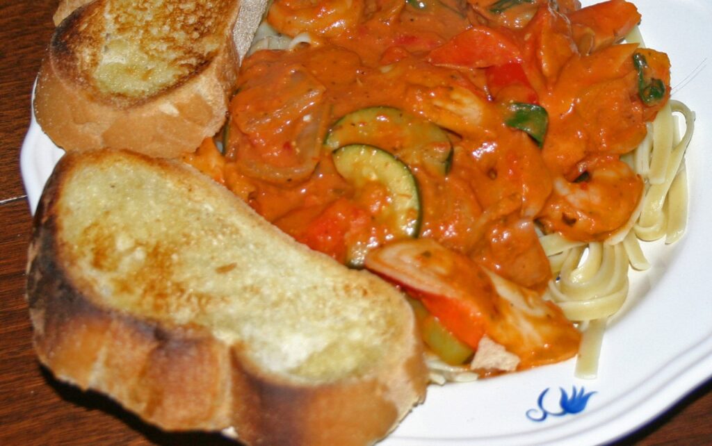 Creamy Tomato Vodka Sauce over seafood, cooked vegetables, and pasta