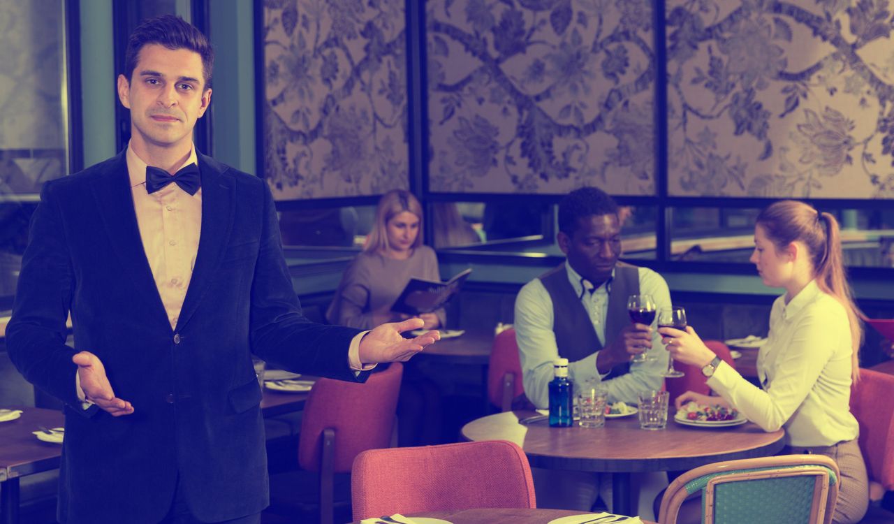 Polite confident waiter inviting to visit modern urban restaurant