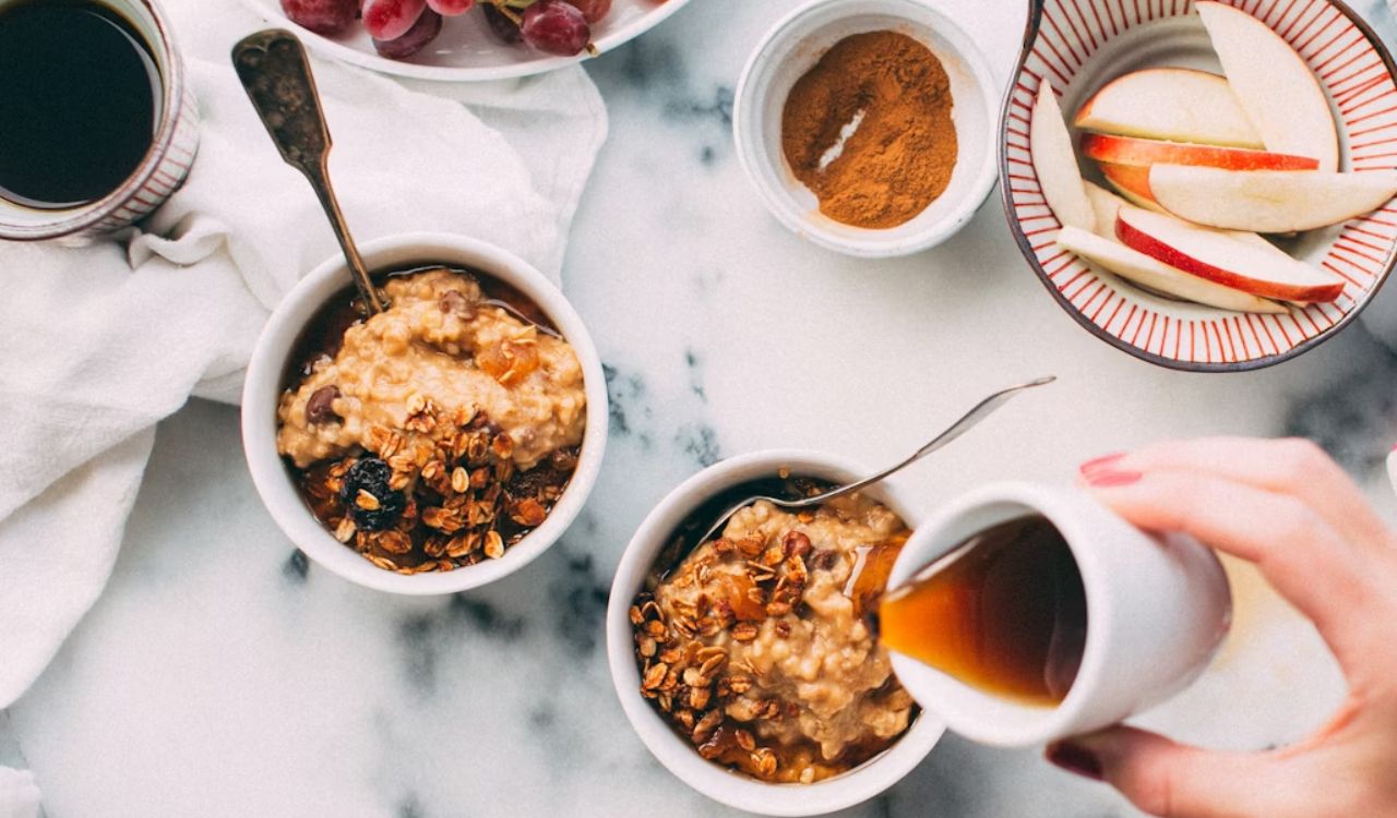 Pouring maple syrup on breakfast bowl