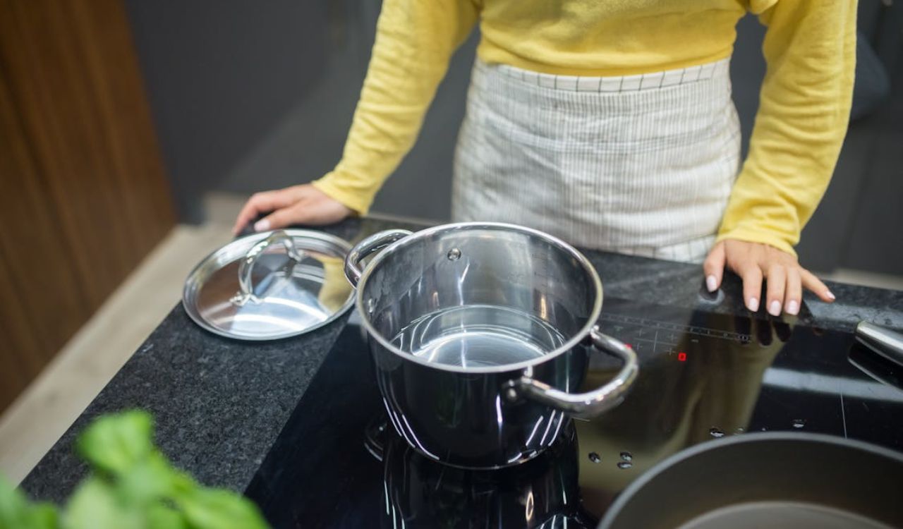Standing by glass stove with a steel pot